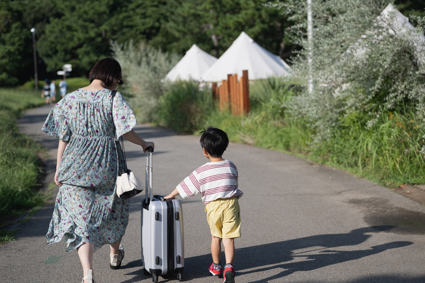 夏の家族旅行・スーツケースを持つファミリーイメージ