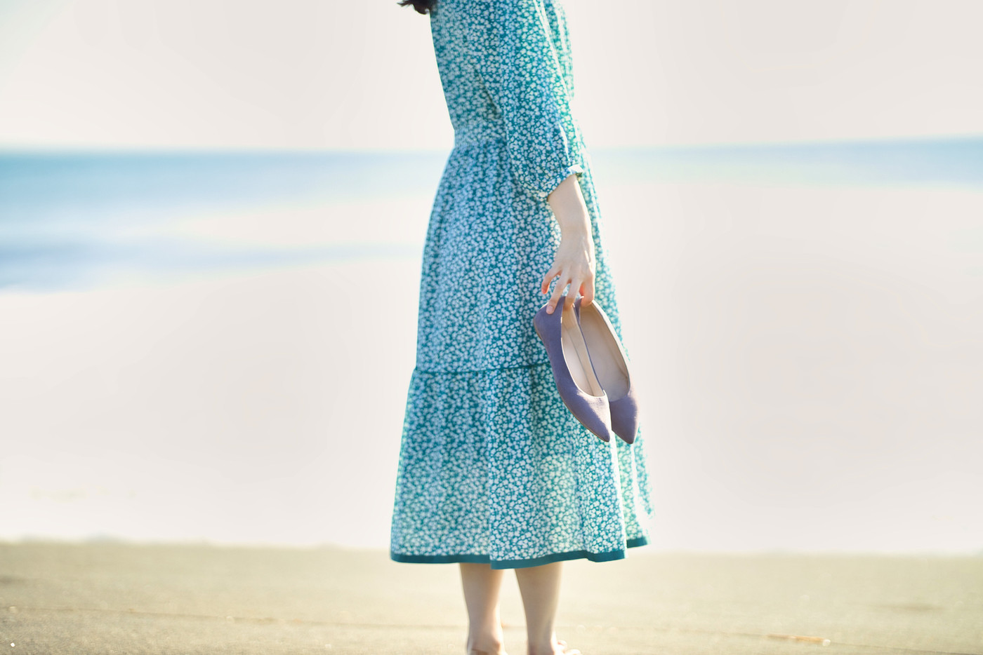 砂浜に立つワンピースの若い女性