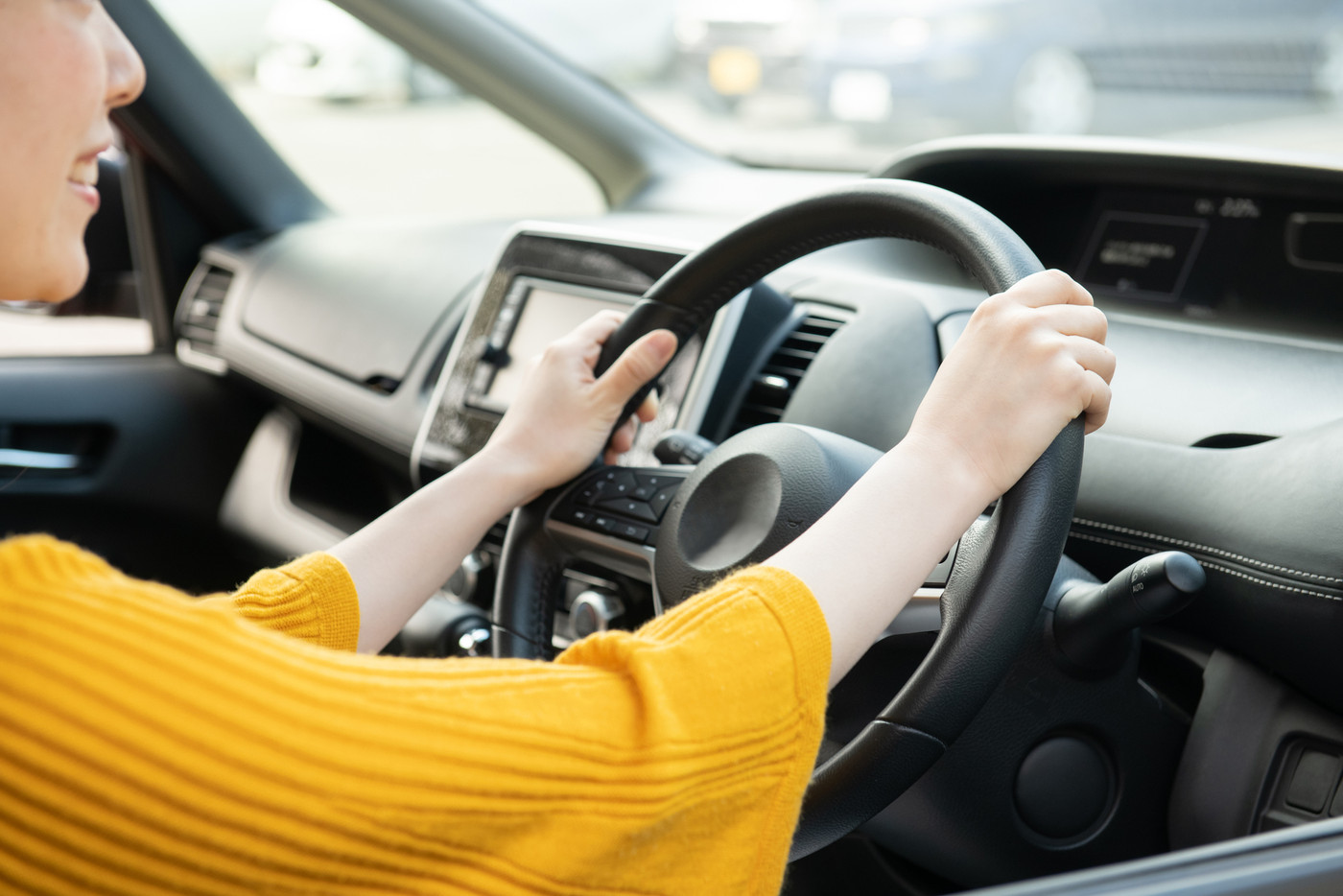 自動車のハンドルを握る手元　運転する日本人女性　ドライブ