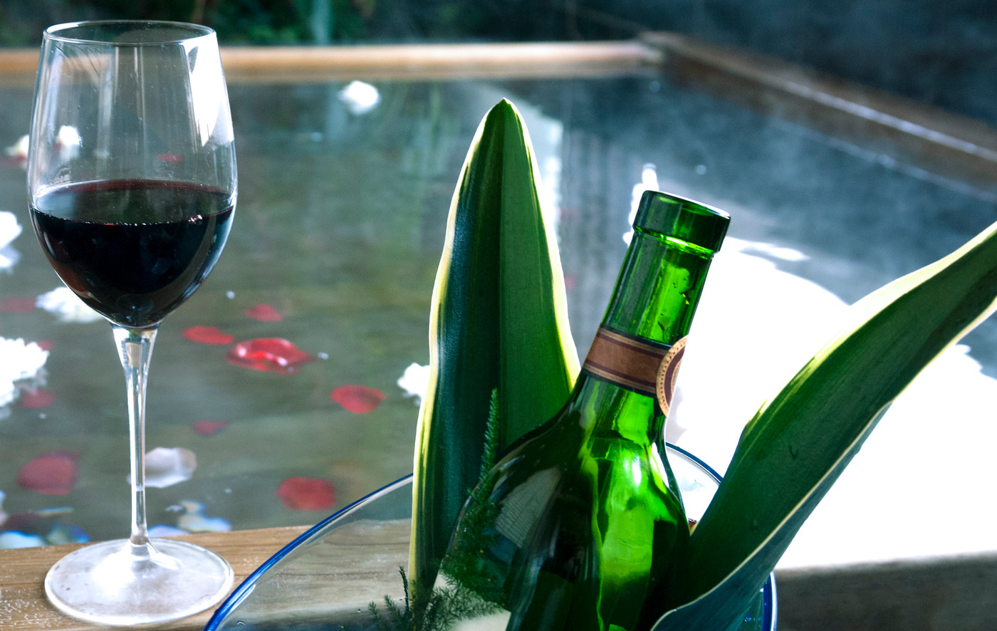 花びらの浮かんだ温泉とワインとワイングラス