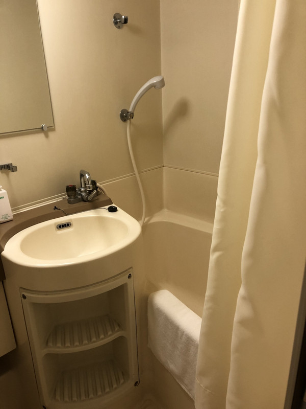 欠陥のシャワーヘッドとカーテン、足拭きタオルはビッショリ。