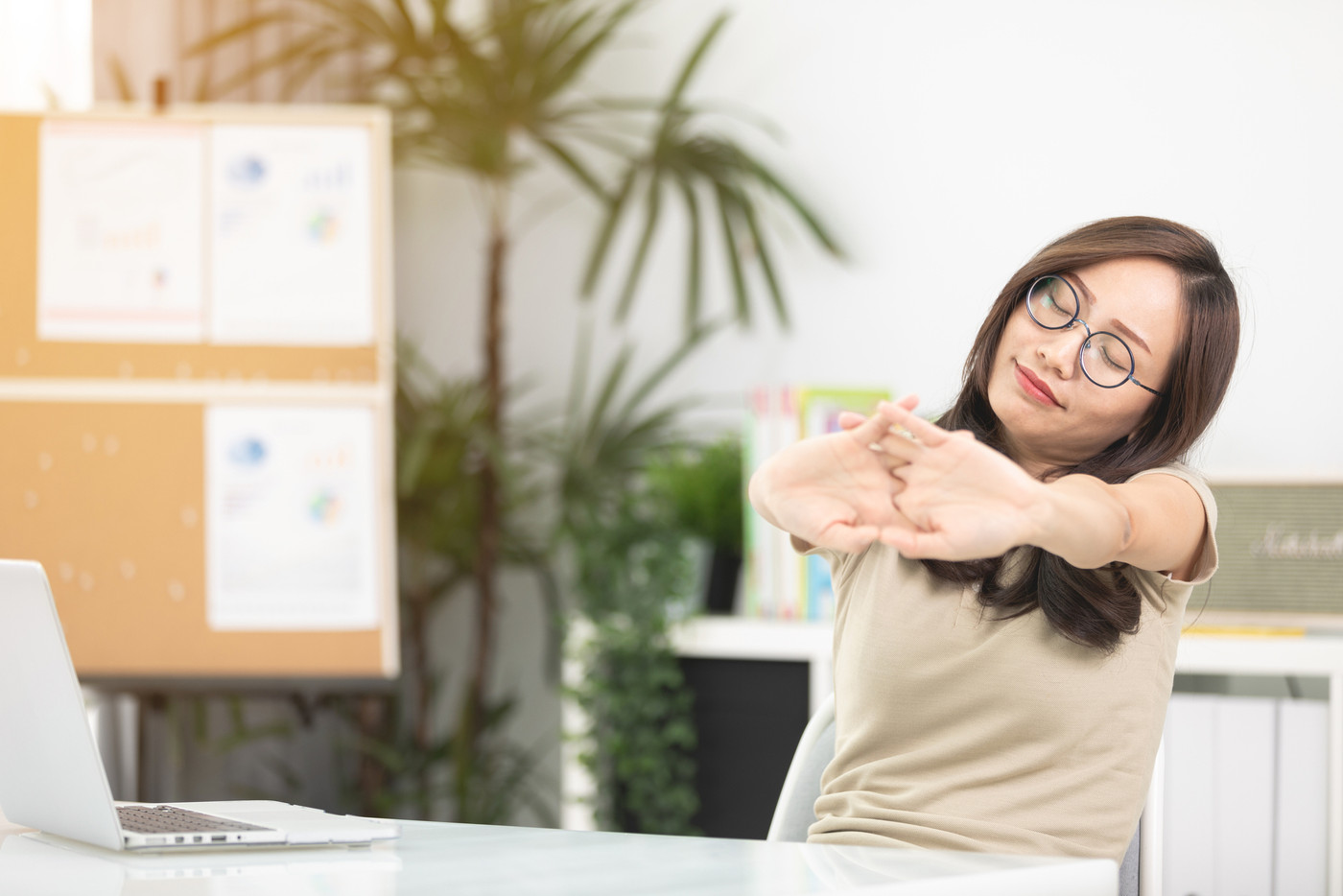 Young asian businesswoman touching massaging stiff neck to relie