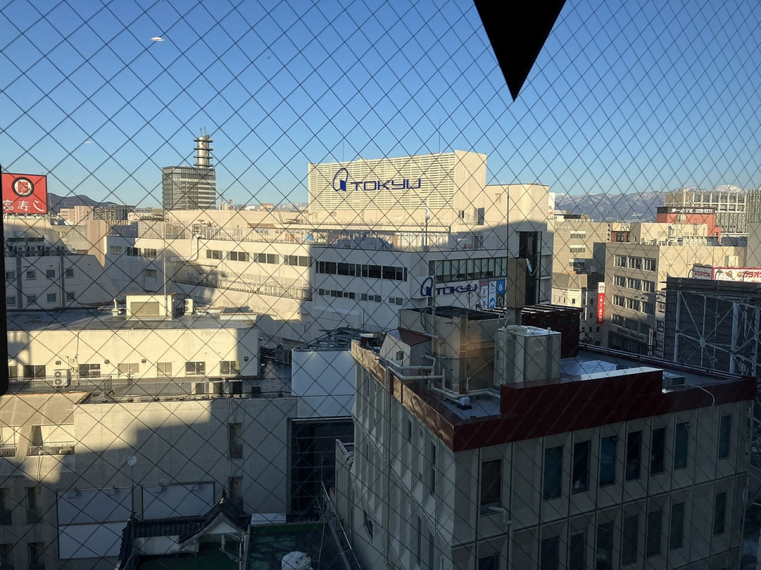 窓からの景色、街の奥には山々の姿