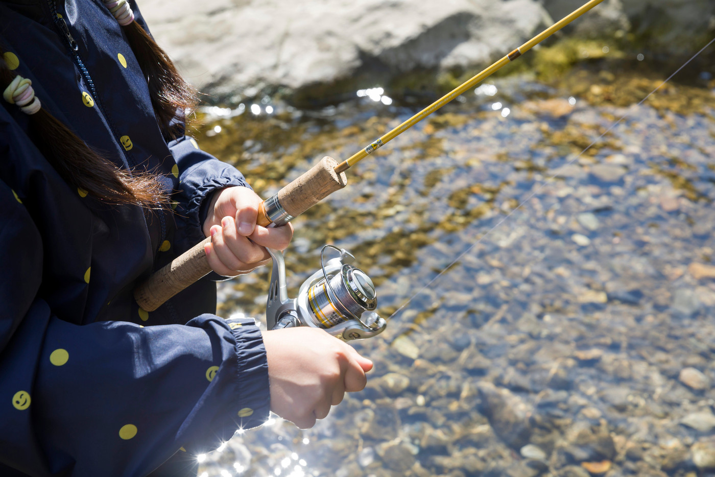 渓流釣りイメージ　釣竿を持つ子供手元