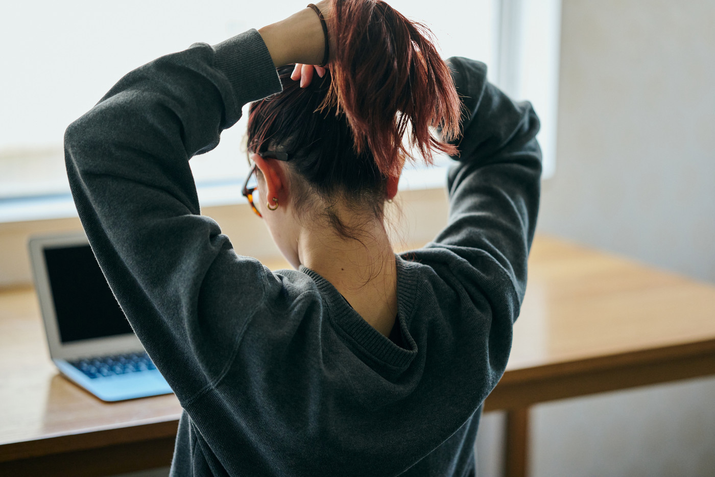 髪を後ろに束ねる若い女性