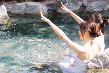 Two young women relaxing in an open-air bath