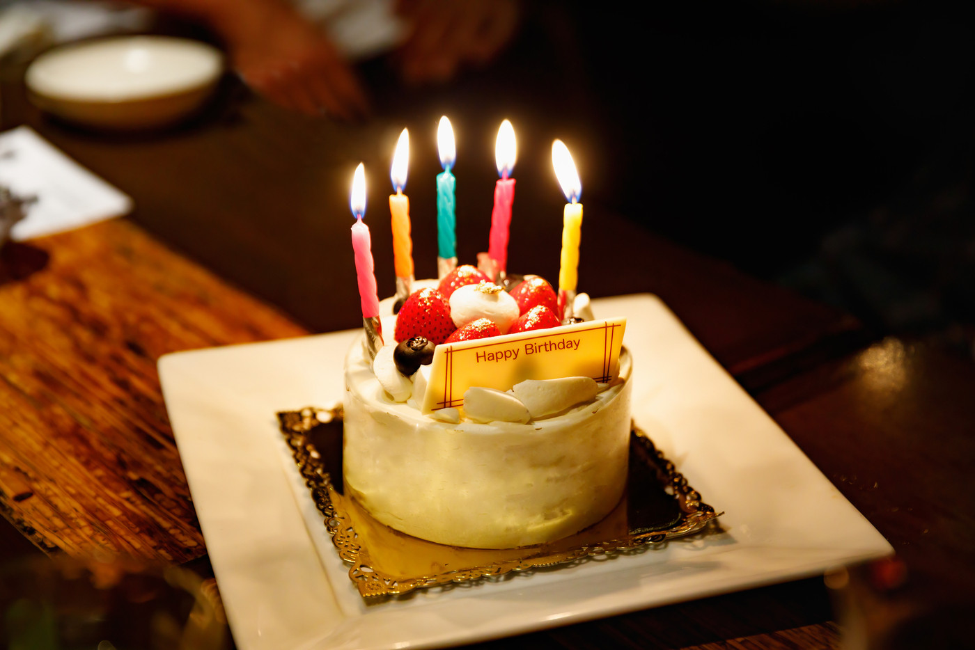 ロウソクの火が灯った誕生日用ケーキ