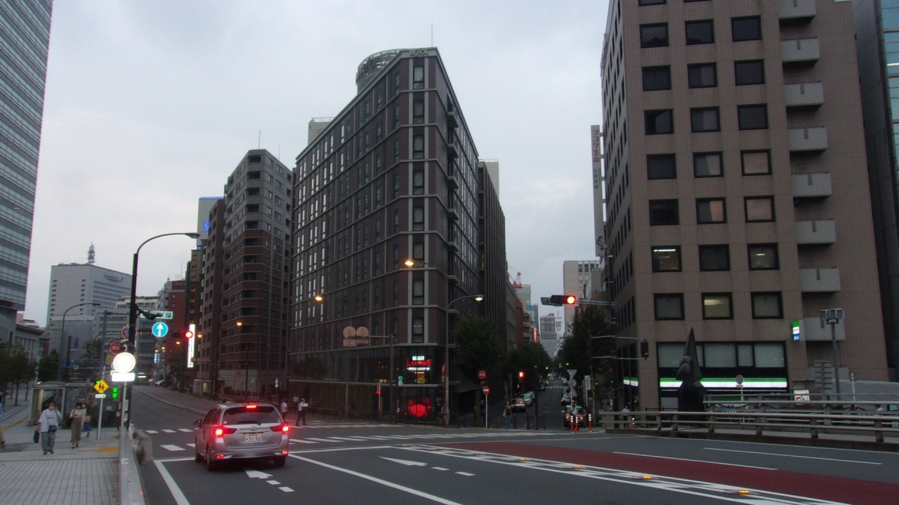 三角形の敷地に建つ。新しいが暗めのデザイン。2階角が食堂。