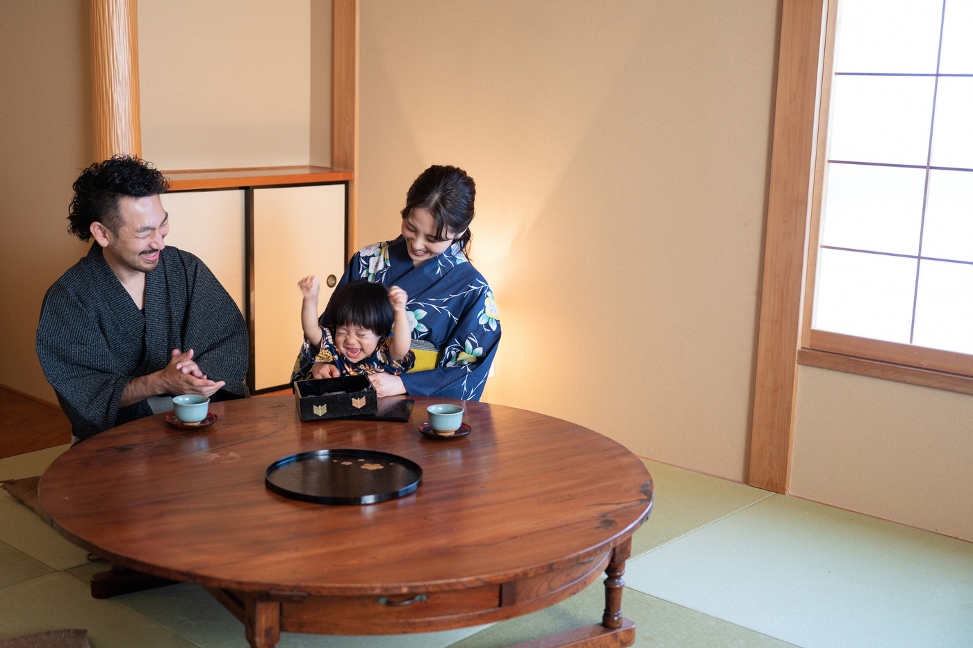旅行素材としても使いやすい、温泉地を訪れる若く美しい日本人家族 広角コピースペースあり