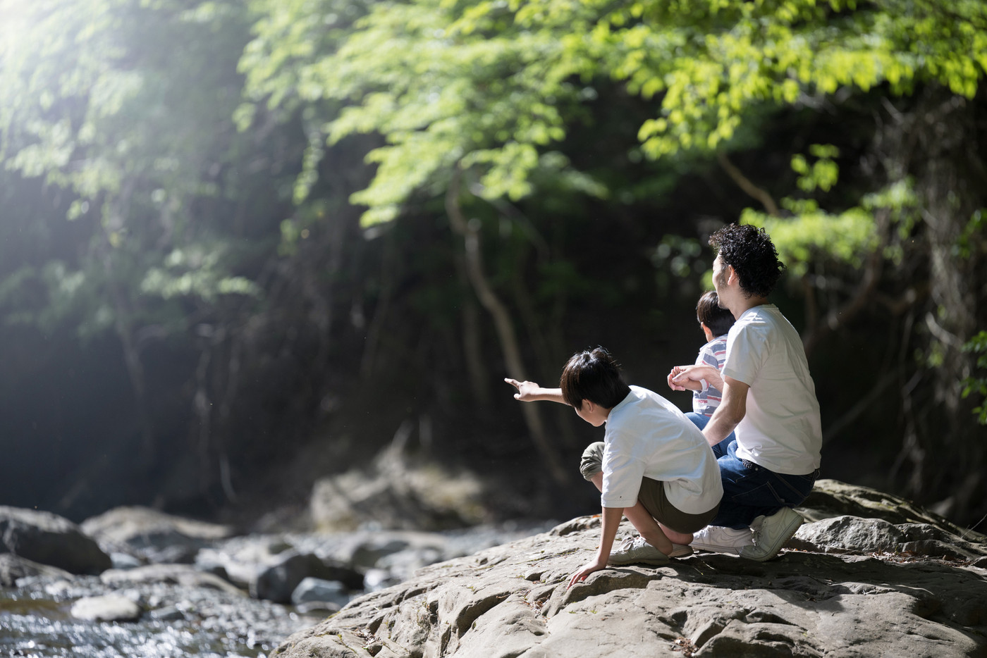 川で遊ぶ兄弟とパパの夏休みの家族旅行　レジャーやアウトドア、キャンプなど冒険のイメージ　広角