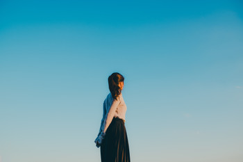 Blue sky and a woman in a one-piece dress