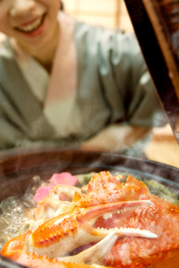 A woman in a yukata who opens the lid of the pot