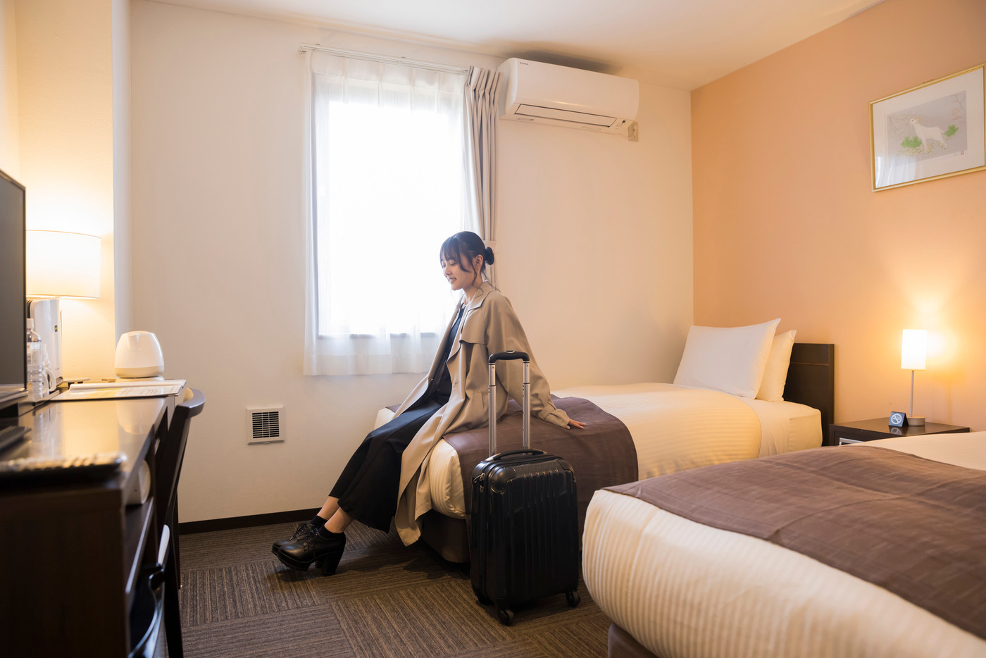 チェックインして客室に到着する若い女性　旅行、出張イメージ